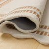 Edge of Scottie Ivory Rust Rug curling up displaying thickness and back side fabric