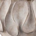 Close-up of irregular textured swells on the concrete base showing weathered gray and beige hues