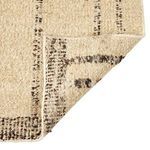 Folded rug corner emphasizing thick wool weave and detailed edge stitching