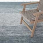 Navy ombre rug styled in a room with woven wooden chair showing scale and use