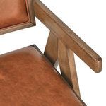 Close-up on Dolton Arm Chair’s wooden armrest with leather seat corner visible