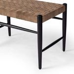 Close-up on the corner of Wyatt Bench showing tapered black oak leg and woven leather seat