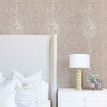 Taupe shagreen wallpaper installed in bedroom with vertical pattern, white bed, and bedside table with lamp and books
