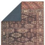 Rug flipped to show solid dark backing and one folded corner