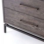 Low-angle close-up showing bottom iron base frame and the bottom drawer’s dark wood surface