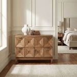Musashi Walnut console table positioned in a bright room beside bedding, decorated with stacked books and a white vase.