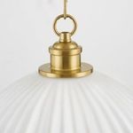 Close-up of aged brass hanging fixture and ring detail atop fluted glass shade