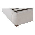 Close-up of light beige velvet upholstery texture and round wooden leg on Colin bed