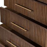 Close-up showing open drawers with matching brass handles and consistent reeded texture.