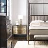 Partial side view of Clarendon canopy bed showing headboard, nightstand, and wooden chest with nearby shoes