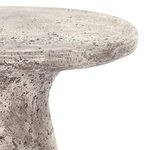 Close-up side angle focusing on rounded edge of the tabletop and rough concrete texture