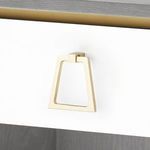 Close-up of gold trapezoid-shaped drawer pull on white drawer front