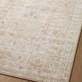 Close-up of rug surface capturing intricate beige, light blue, and muted orange pattern details on hardwood floor