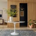 Anniston Lagoon Natural Rug styled in modern living room with wood-paneled wall and white round table