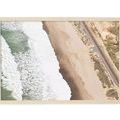 Aerial photograph above Riviera Beach showing waves, sandy shore, railroad track, and a lone surfer waiting to paddle out
