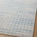 Close-up of rug surface emphasizing soft blue pattern blending on neutral background