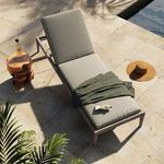 Close rear view focused on black woven backrest support and wood frame with raised head cushion