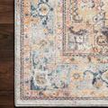 Close-up corner view of Clara Mist rug on dark wood floor highlighting pattern colors and woven edge