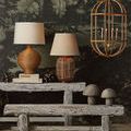Charrette Lantern hanging in a room with rustic lamps, wooden bench, and decorative stone mushrooms