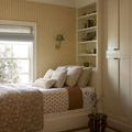 Harvey Ivory Pillow styled on a bed with neutral bedding and light beige wallpaper with white polka dots