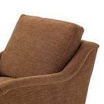 Close-up of brown Lynne Chair back cushion and curved arm in textured upholstery fabric