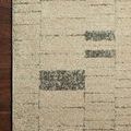 Close-up showing edge detail and subtle texture on taupe rug over dark wood floor