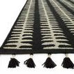 Side angle focusing on black tassels and textured woven pattern of Kahelo rug