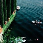 Partial detail of boats and cypress trees on lake with focus on vibrant plant textures and water ripples