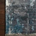 Samra Charcoal Sky Rug with a textured abstract pattern in dark charcoal and sky blue tones on hardwood floor