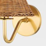 Close-up angled view of woven rattan shades hanging on white chandelier arms