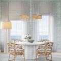Donnybrook Chandelier hanging over round dining table in coastal room setting with rattan chairs and soft curtains