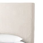 Side angle of queen bed slipcover, highlighting clean hem and draped linen fabric