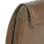 Close-up detail of rolled edge and stitching on the brown leather chair backrest