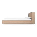Side profile of camel sheepskin upholstered bed showing low height frame with mattress and pillows