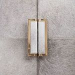 Close-up of rectangular polished brass handle set into hair-on-hide door covering