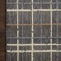 Close-up of Rainier charcoal plaid rug corner highlighting woven pattern and dark wood floor