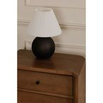 Tuve table lamp placed on a light brown wooden drawer with rounded edges