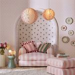 Room setting showing wallpaper with baby pink button spot pattern on side walls