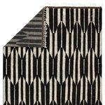 Back side view revealing the rug's woven base and folded corner with visible fringe