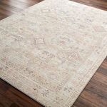 Angled close-up showing the low pile, texture, and subtle color variations of the Marlene dusty coral rug on hardwood floor