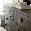 Angled close-up of dresser top with stacked decorative boxes and textured hardware