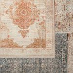 Close overlapping view showing intricate pattern contrasts between rust medallion rug and a dark blue rug underneath