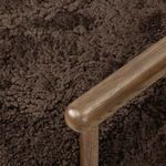 Close-up of Bennett Chair’s oak armrest corner junction with shearling seat