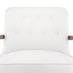 Close-up of chair back cushion showing evenly spaced button tufting on white linen fabric