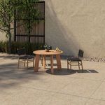 Outdoor patio scene highlighting round natural teak outdoor dining table with four black strap chairs