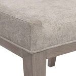Close-up of textured beige upholstery and seam detail on Linea chair seat with light ash wood leg