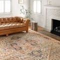 Jocelyn Sand Multi rug styled in cozy room with tan tufted leather sofa, white fireplace, and natural decor