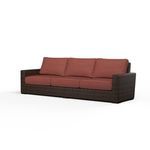 Three-seat outdoor sofa with wide armrests, wrapped in dark cognac multi-color resin wicker with rust-colored cushions