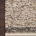 Close-up corner of Reyla Granite rug on dark wood floor highlighting woven yarn texture and braided border