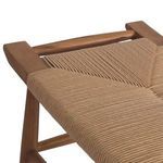 Angled close-up of woven all-weather wicker texture wrapping around teak seat frame